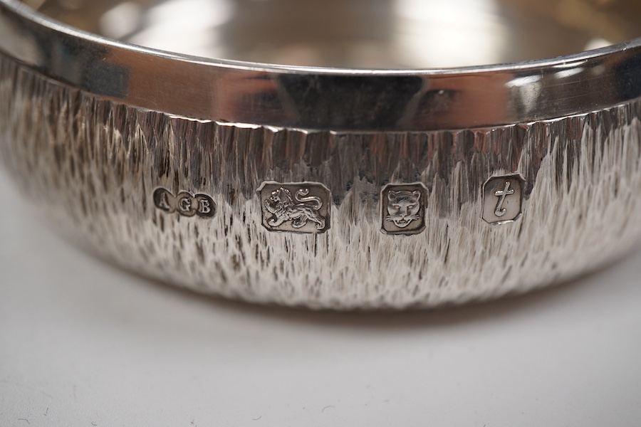An Elizabeth II bark effect silver shallow bowl by Adrian Gerald Benney, London, 1974, top diameter 9cm, together with a similar shallow dish, by Adrian Gerald Benney, London, 1974, diameter 11.9cm, 8.8oz.
